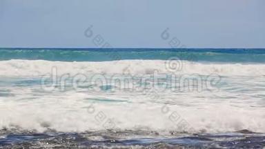 大西洋上的一波又一波缓慢的海浪冲向特内里费的黑色卵石海岸